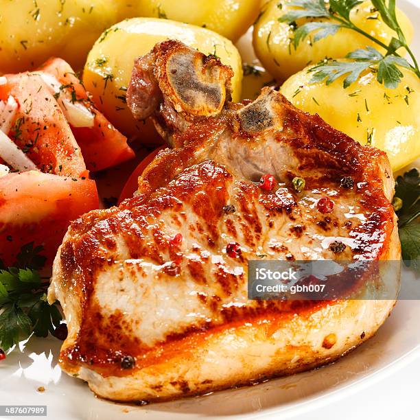 Pork Chop Boiled Potatoes And Vegetables On White Background Stock Photo - Download Image Now