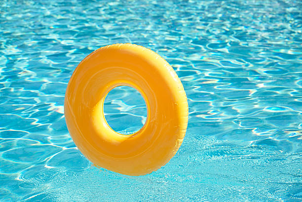istock floating ring on blue water swimpool with waves reflecting 487608497