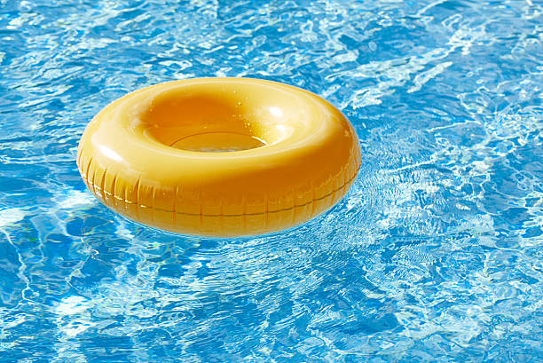 istock floating ring on blue water swimpool with waves reflecting 487608499