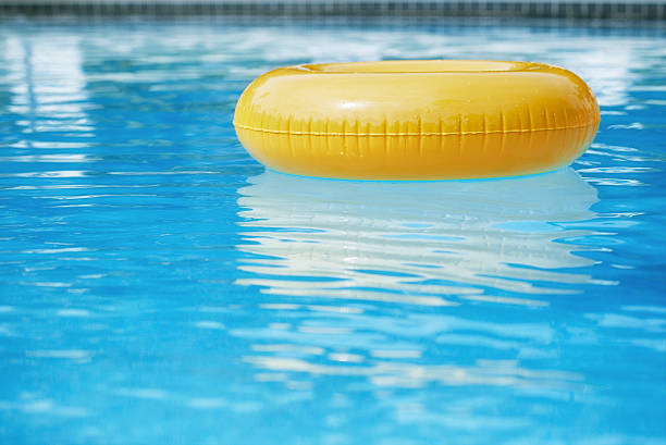 pierścień pływające w niebieski wody fale odzwierciedlające swimpool z - swimming tube inflatable circle zdjęcia i obrazy z banku zdjęć