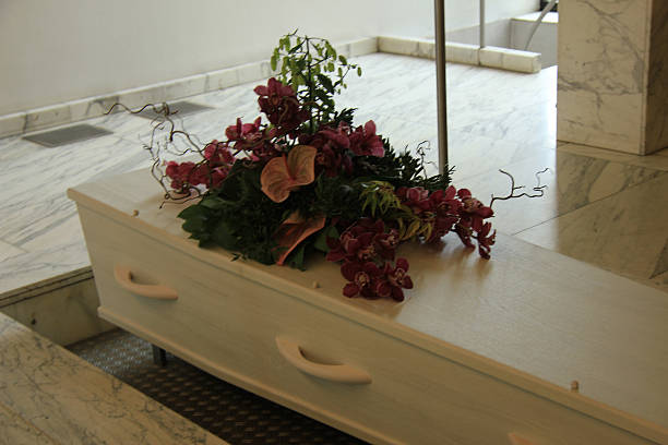 istock Coffin with funeral flowers 487608791