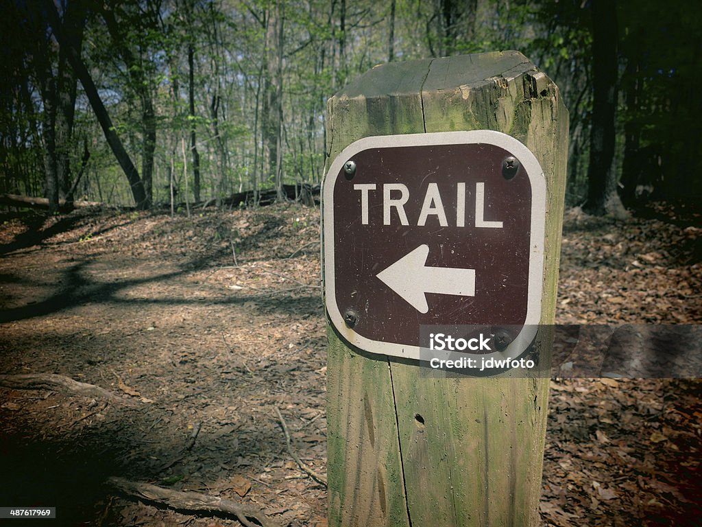 Trail Marker A filtered photo of a trail marker sign with an arrow pointing to the correct direction. Hiking Stock Photo