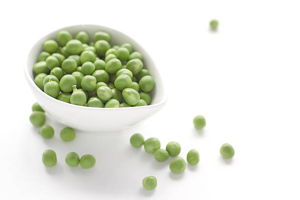 istock Green Peas in bowl isolated on white 487618527