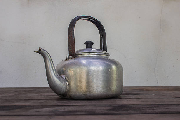 istock Kettle the on wooden table with cracked gray walls 487619231