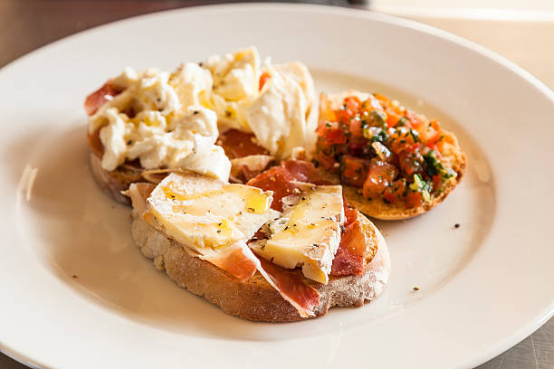 istock Bruschetta with prosciutto, goat cheese and fried tomatoes 487619332