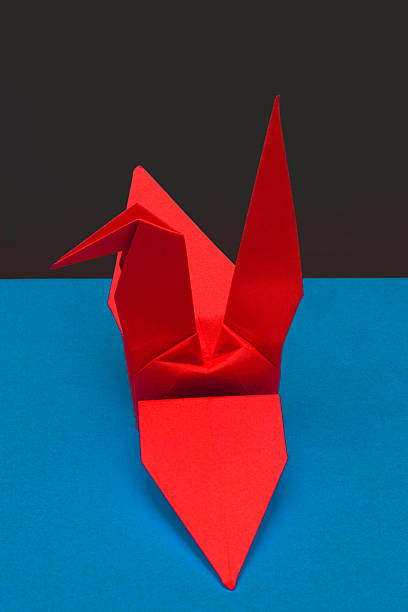 istock Red Paper Crane Over Blue and Black Background 487619599