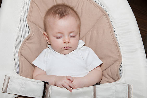 istock Young infant sleeping in a soft chair with arms crossed 487623492