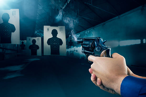 Police officer firing a gun at shooting range Police officer holding a gun at a shooting range target shooting stock pictures, royalty-free photos & images