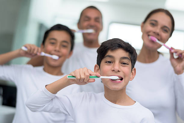 glückliches familienporträt putzt sich die zähne - human teeth child smiling family stock-fotos und bilder