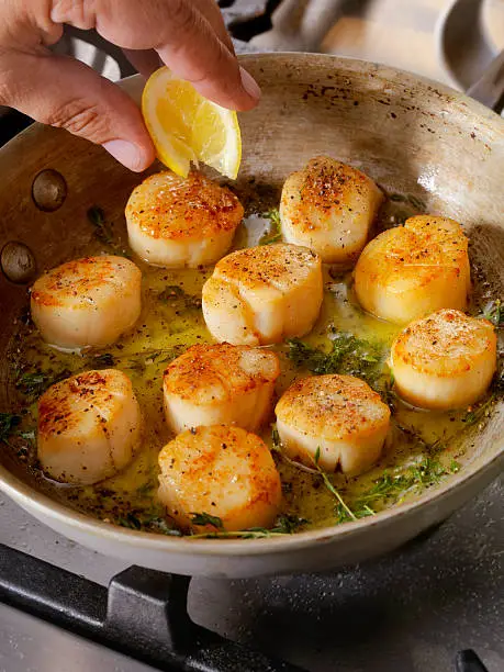 Pan Searing Scallops in Butter, olive oil and fresh garlic and thyme -Photographed on Hasselblad H3D2-39mb Camera