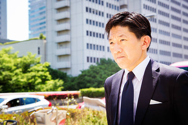 istock Japanese businessman walks to work with grim determination 487635764