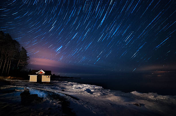 star trails over озера на ночь - lake night winter sky стоковые фото и изображения