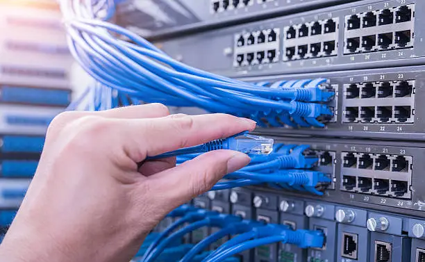 Photo of hand with network cable in a technology data center