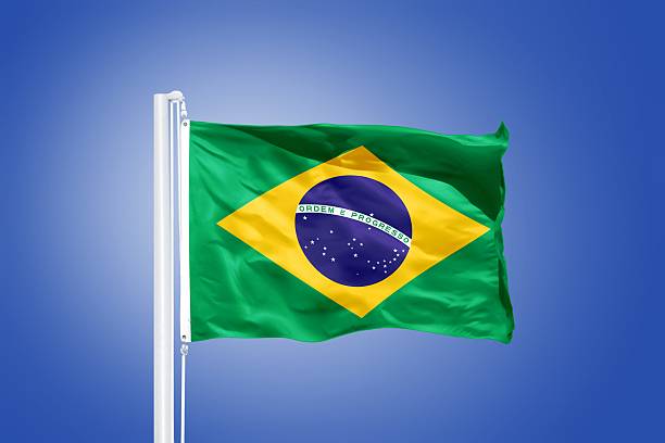 istock Flag of Brazil flying against a blue sky 487647300