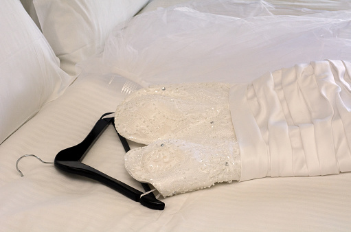 Wedding dress on double bed.