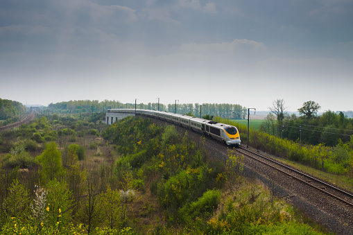 Coubert, France, April 12, 2014 : An Eurostar high speed train is crossing between two forest.