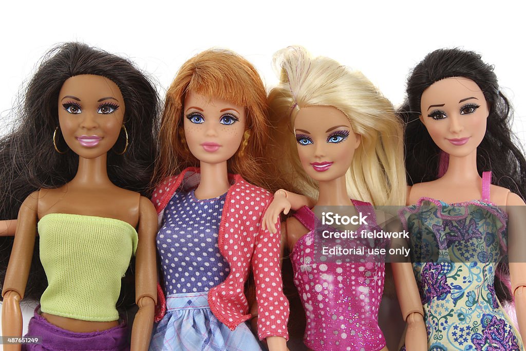 Four Barbie fashion dolls on white background Trowbridge, Wiltshire, UK - April 23, 2014: Photograph of 4 plastic Barbie doll toys from Matel. Fashion Doll Stock Photo