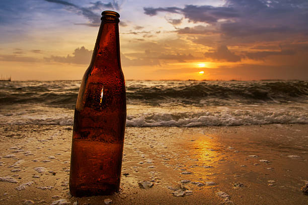 istock Bottles of beer on the beach at sunset. 487652164