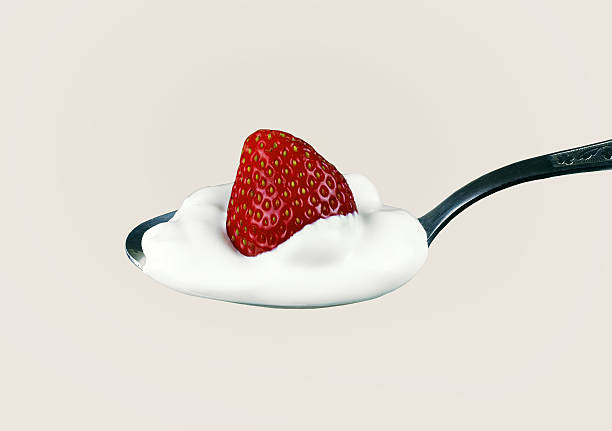 istock fresh strawberries and cream on a silver spoon 487652552