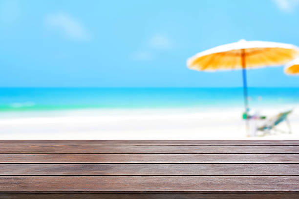 istock Old dark brown wood table top on blurred beach background 487658090