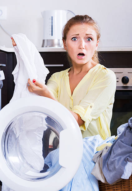 istock Upset girl looking at linen after laundry 487665264