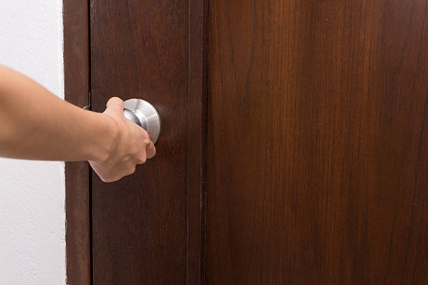 istock hand hold handle of wood door 487666174