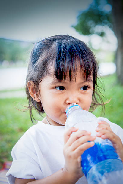 istock Child is drinking water in the park 487667454
