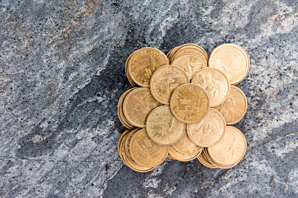 istock Pile of dollar coins on a stone surface 487668641