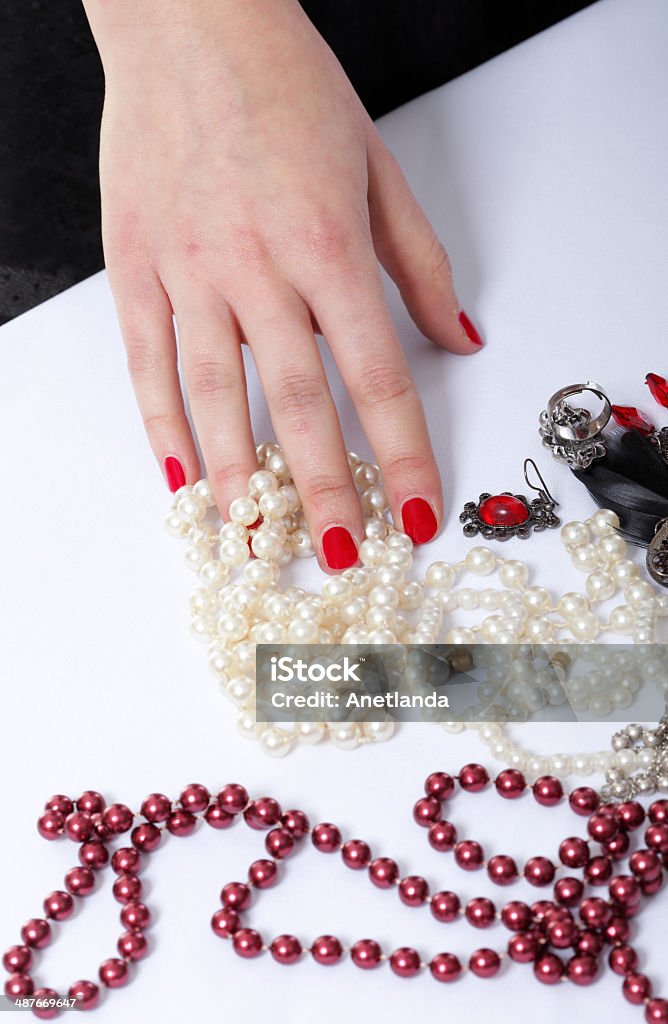 Female hand choosing pearl necklace Female hand choosing pearl necklace on white table. Luxury. Adult Stock Photo