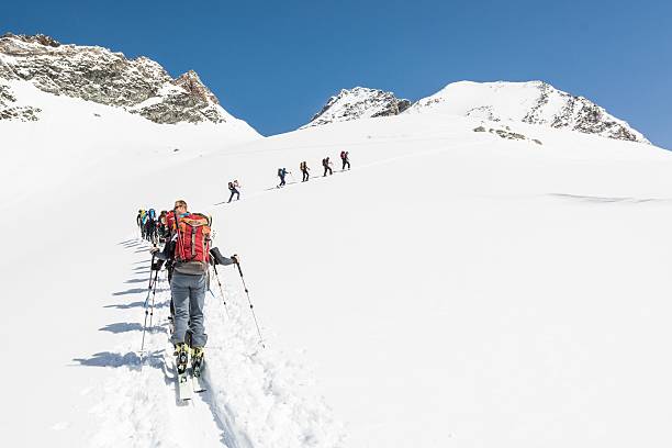 istock Line of people ascending a mountain on skies 487670655