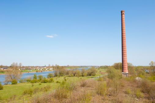 Stone chimney of an old Dutch brick factory in river landscape