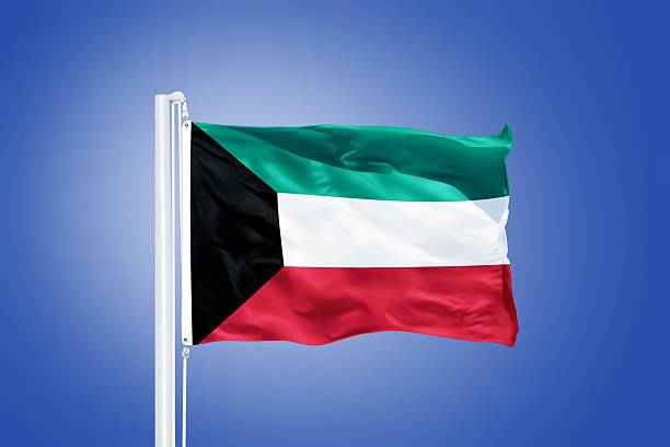 istock Flag of Kuwait flying against a blue sky 487671286