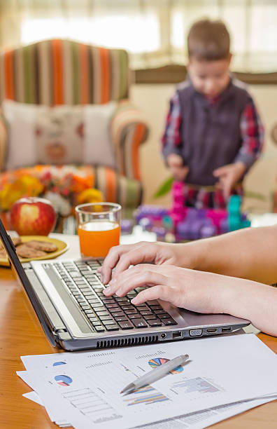 istock Woman hands writing in notebook and boy playing 487671419