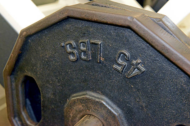 istock Iron weight plates and exercise equipment in gym 487671908