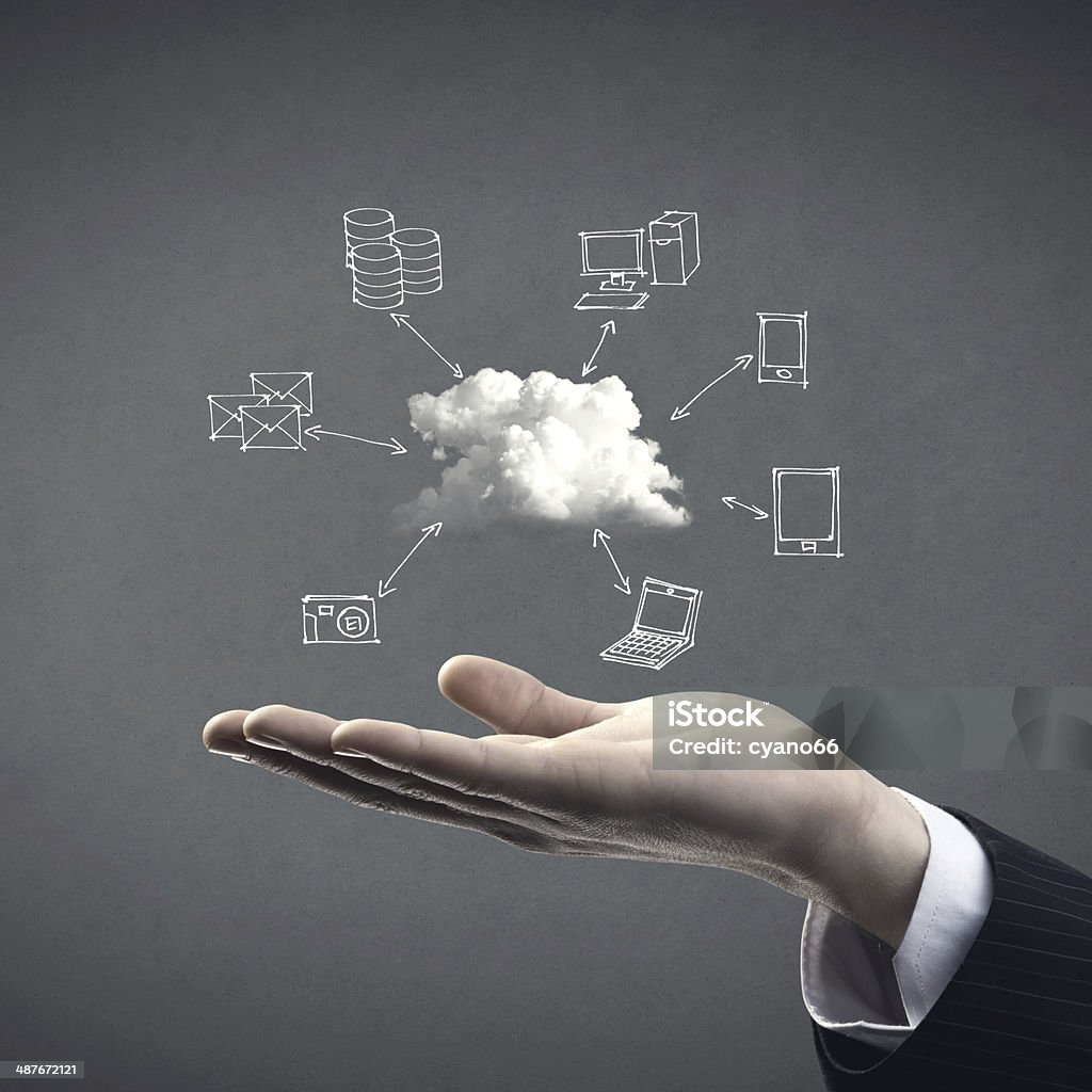 Cloud computing Hand drawn technology and computer icons around cloud with hand on gray background, cloud computing concept. Business Stock Photo