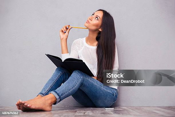 Girl Sitting On The Floor With Notepad And Pencil Stock Photo - Download Image Now - 2015, Adult, Adults Only