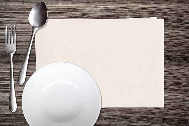 istock White dish spoon fork and and paper on wood background 487678630