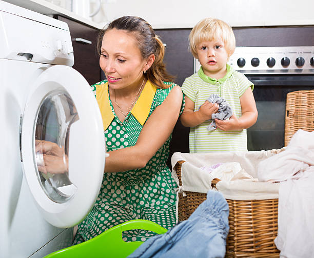 istock Woman with child near washing machine 487679342