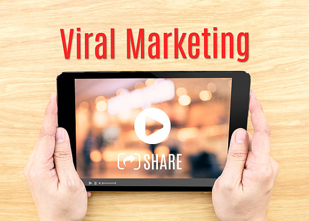 istock Hand holding tablet with Viral marketing word on wood table 487680862