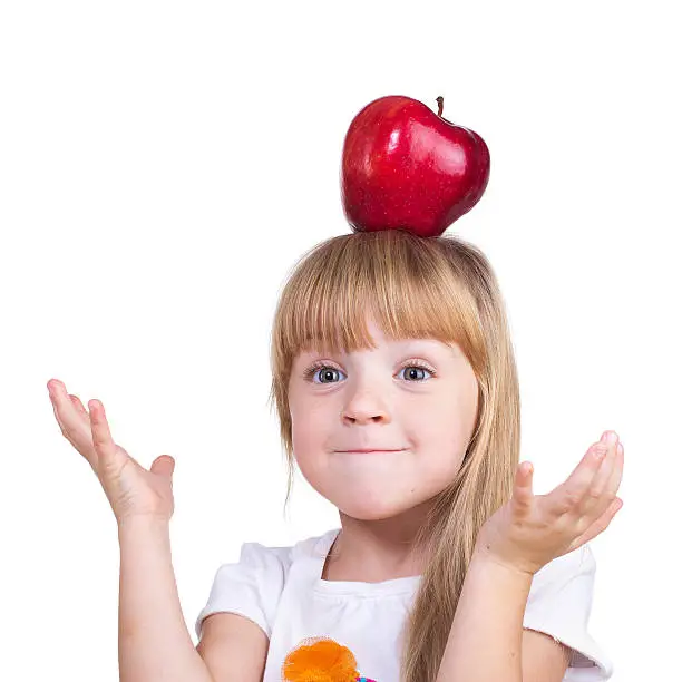 Girl blonde with long hair plays about with a big red apple on her head