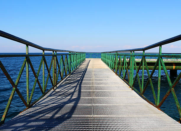 Pier at the sea with green railing stock photo