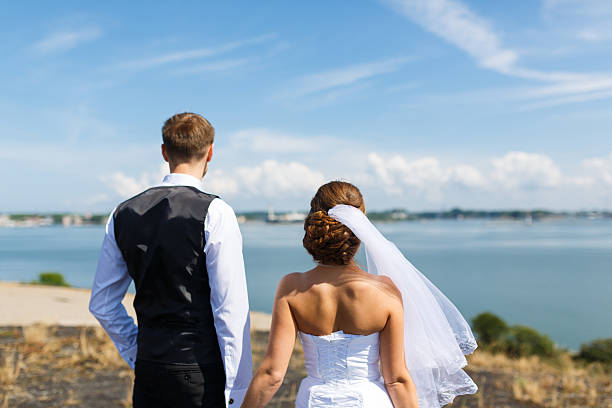 istock Wedding couple looking out to sea 487685742