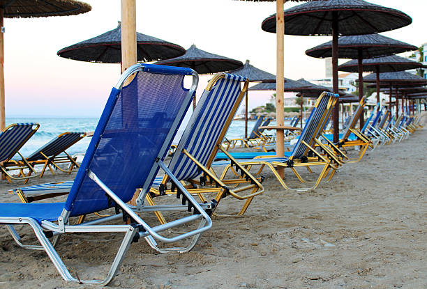 Sandy beach with many loungers and parasols stock photo