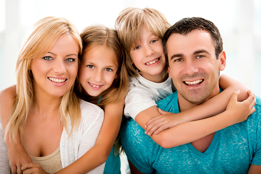 Portrait of happy mid adult parents with son and daughter looking at the camera.