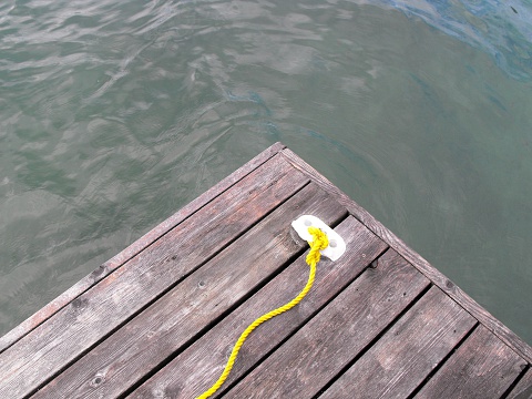 Wooden dock with yellow rope, dark water