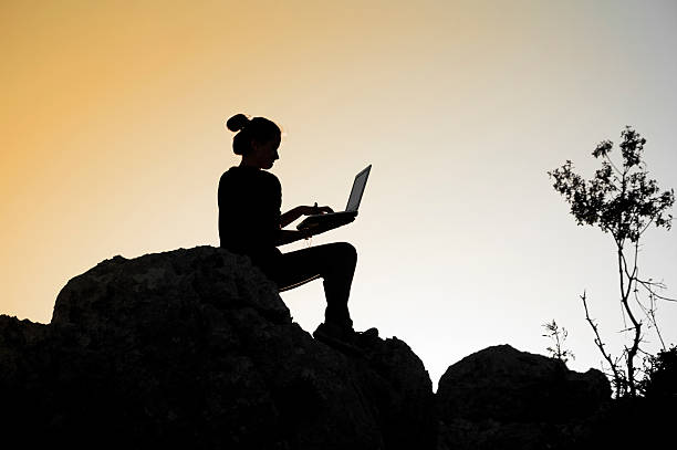 istock Girl working with laptop at sunset 487690201