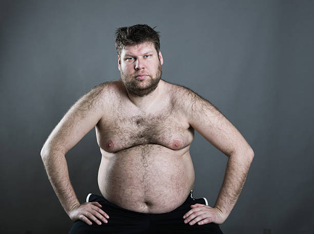 Fat man isolated on gray background Sitting fat man isolated on gray background fat guy no shirt stock pictures, royalty-free photos & images