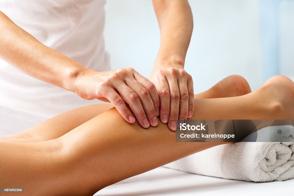 Detail of hands massaging human calf muscle. Detail of hands massaging human calf muscle.Therapist applying pressure on female leg. Massaging Stock Photo