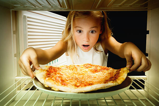 istock girl found pizza in fridge 487692455