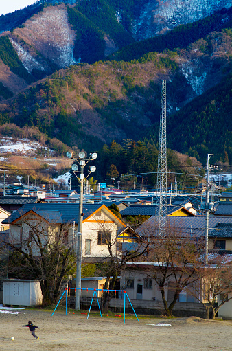 Katsunuma, Japan - March 6, 2014: young boy plays soccer in a field in the small Japanese city (or village) called Katsunuma in the Yamanashi Prefecture.  